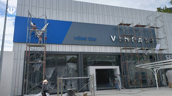 Nhân viên đang thi công bảng hiệu alu chữ nổi