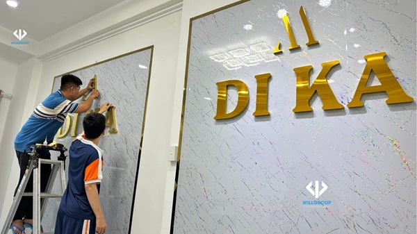 Nhân viên đang thi công bảng hiệu alu chữ nổi tại Di Ka