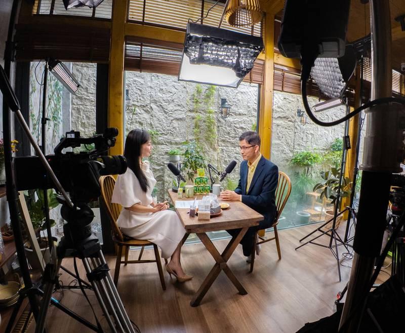 Hai người đang trao đổi trong buổi ghi hình với thiết bị và ánh sáng chuyên nghiệp cho dịch vụ quay video podcast trọn gói.